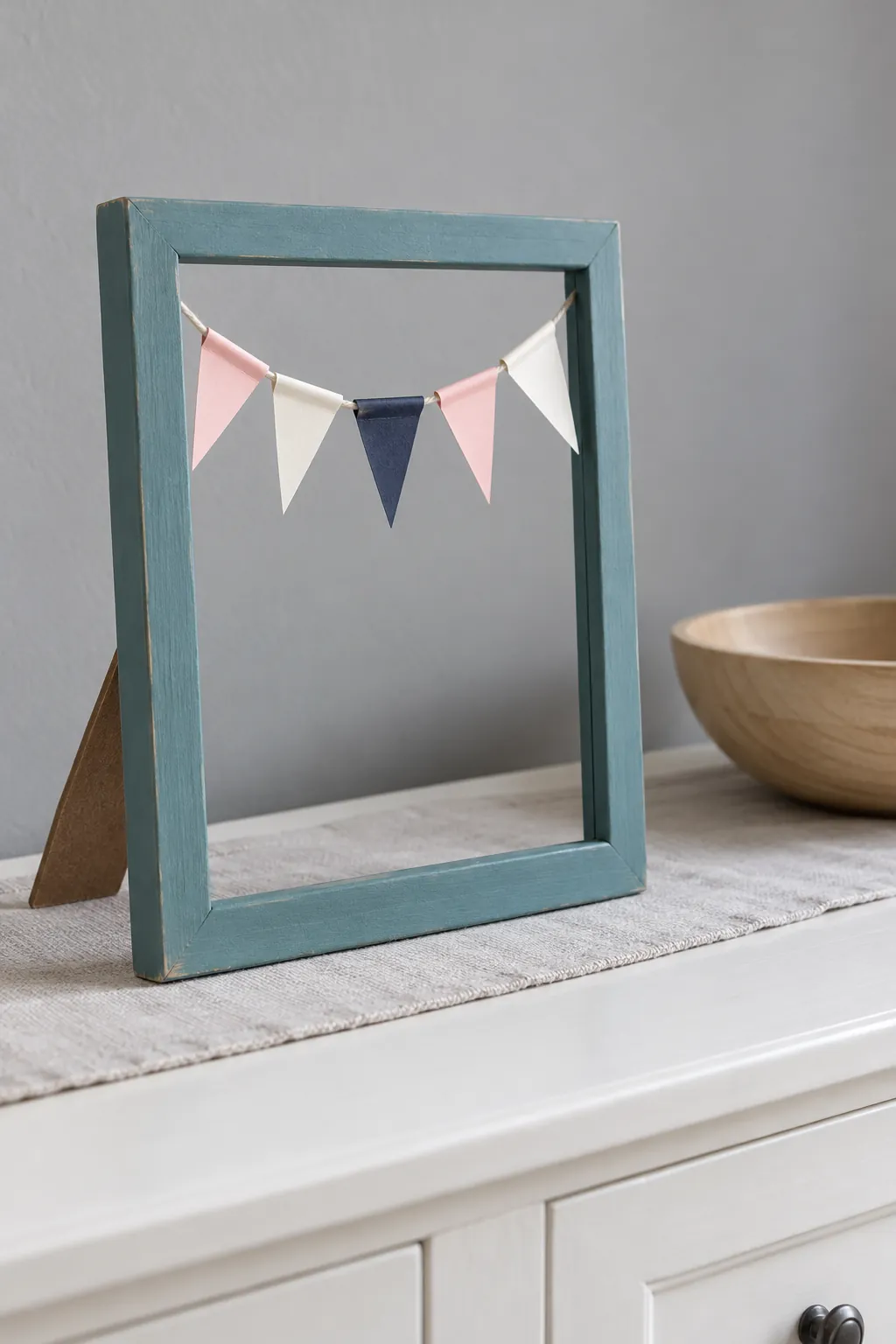 Tiny paper bunting inside a glassless tabletop frame