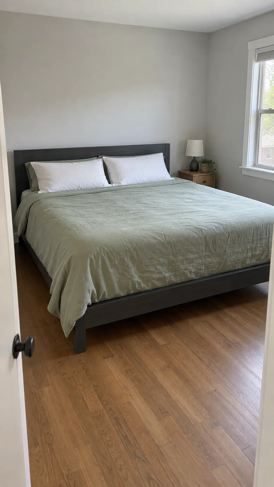 King bed on a slim frame with narrow bedside furniture and clear floor access