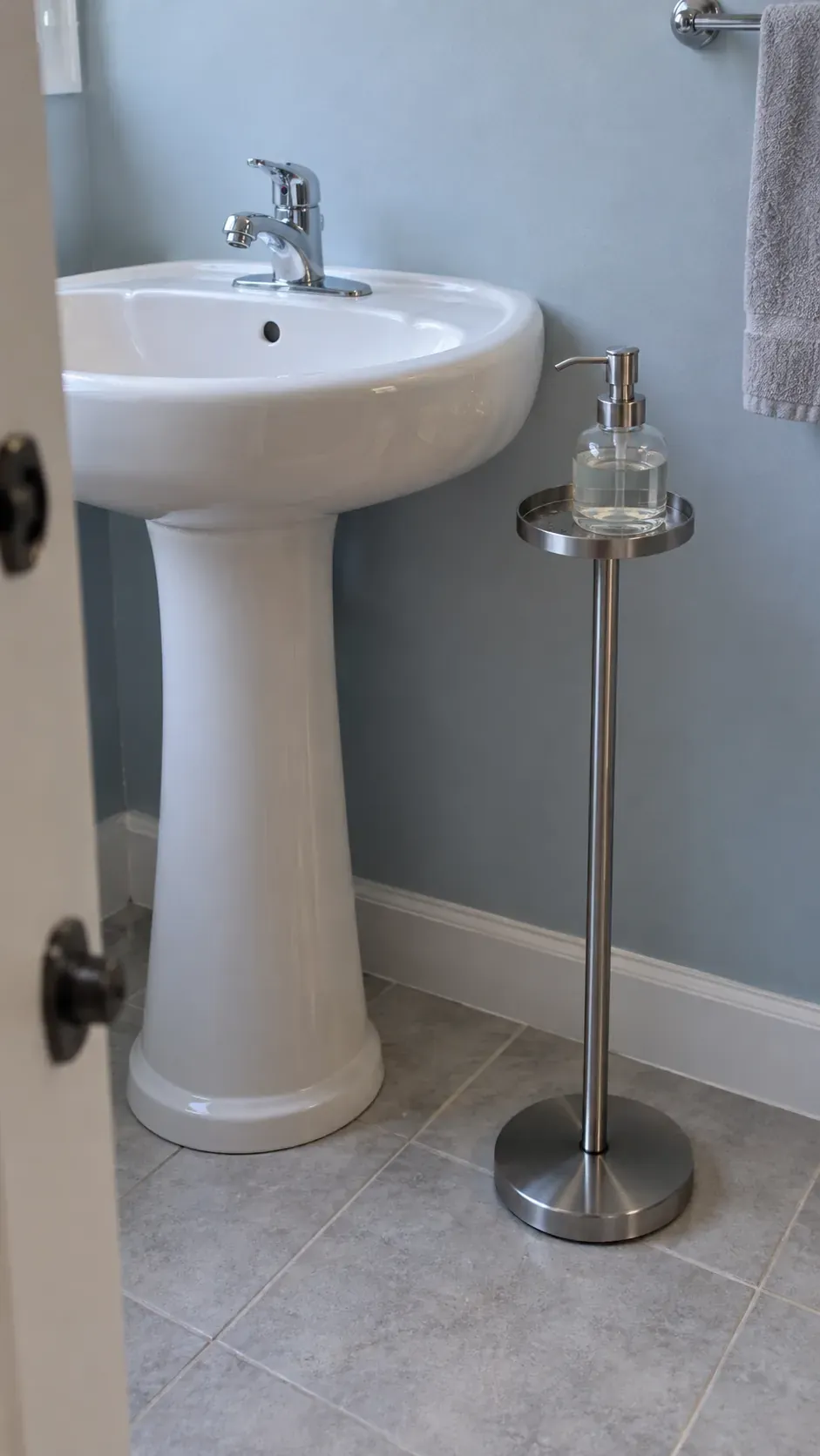 Weighted freestanding dispenser stand, low doorway view, blue painted wall and stainless steel