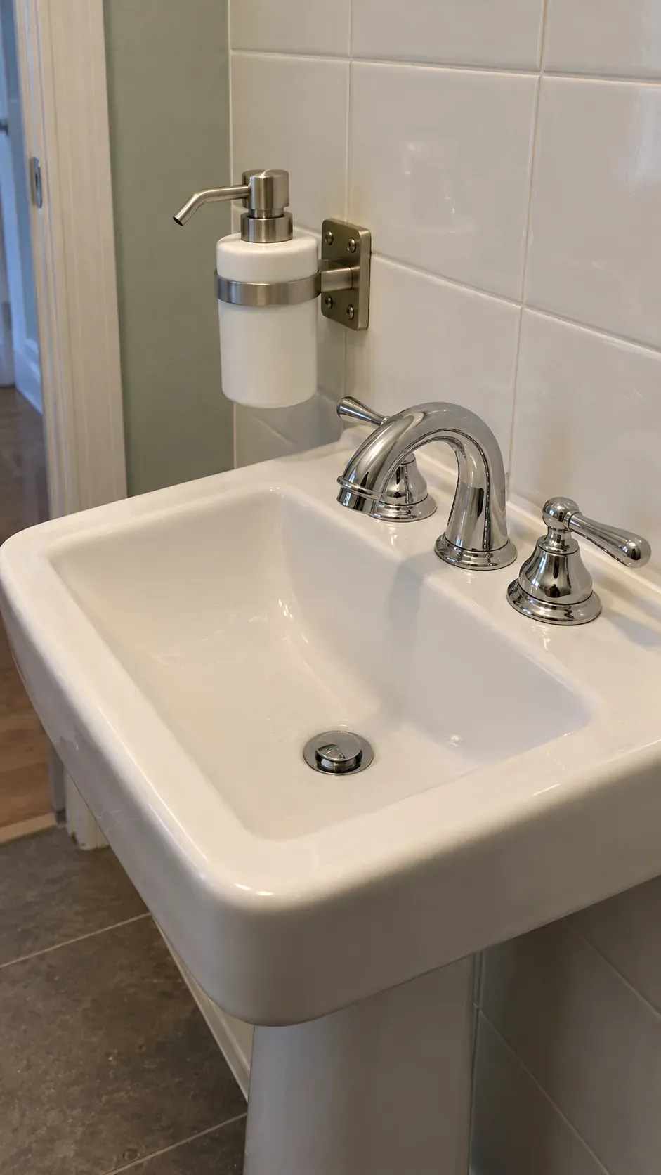 Mounted soap nozzle alignment over a square bowl, close oblique tile detail