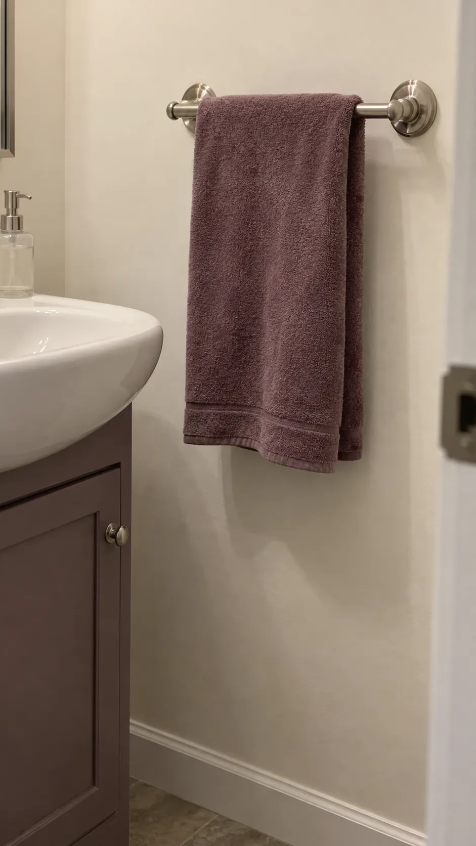 Dusty plum hand towel repeats a small accent in an existing powder room