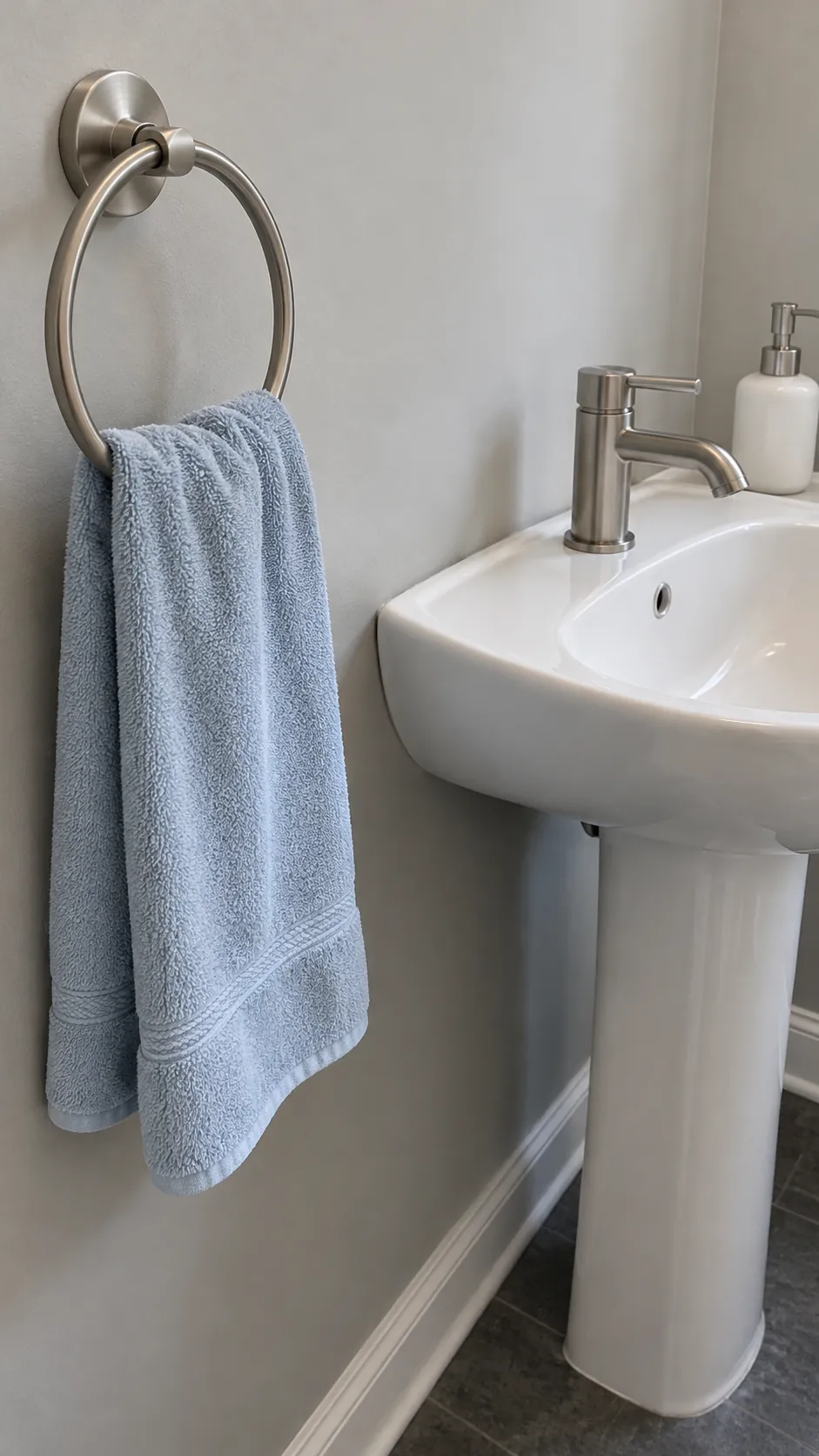 Nickel towel ring beside a nickel mixer in an existing powder room