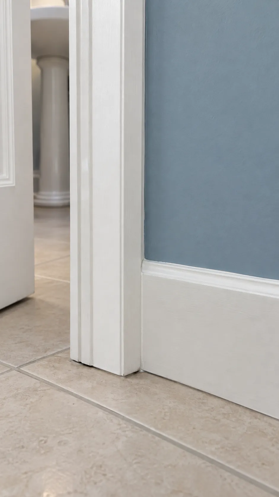 One trim white at a clean doorway corner in an existing powder room