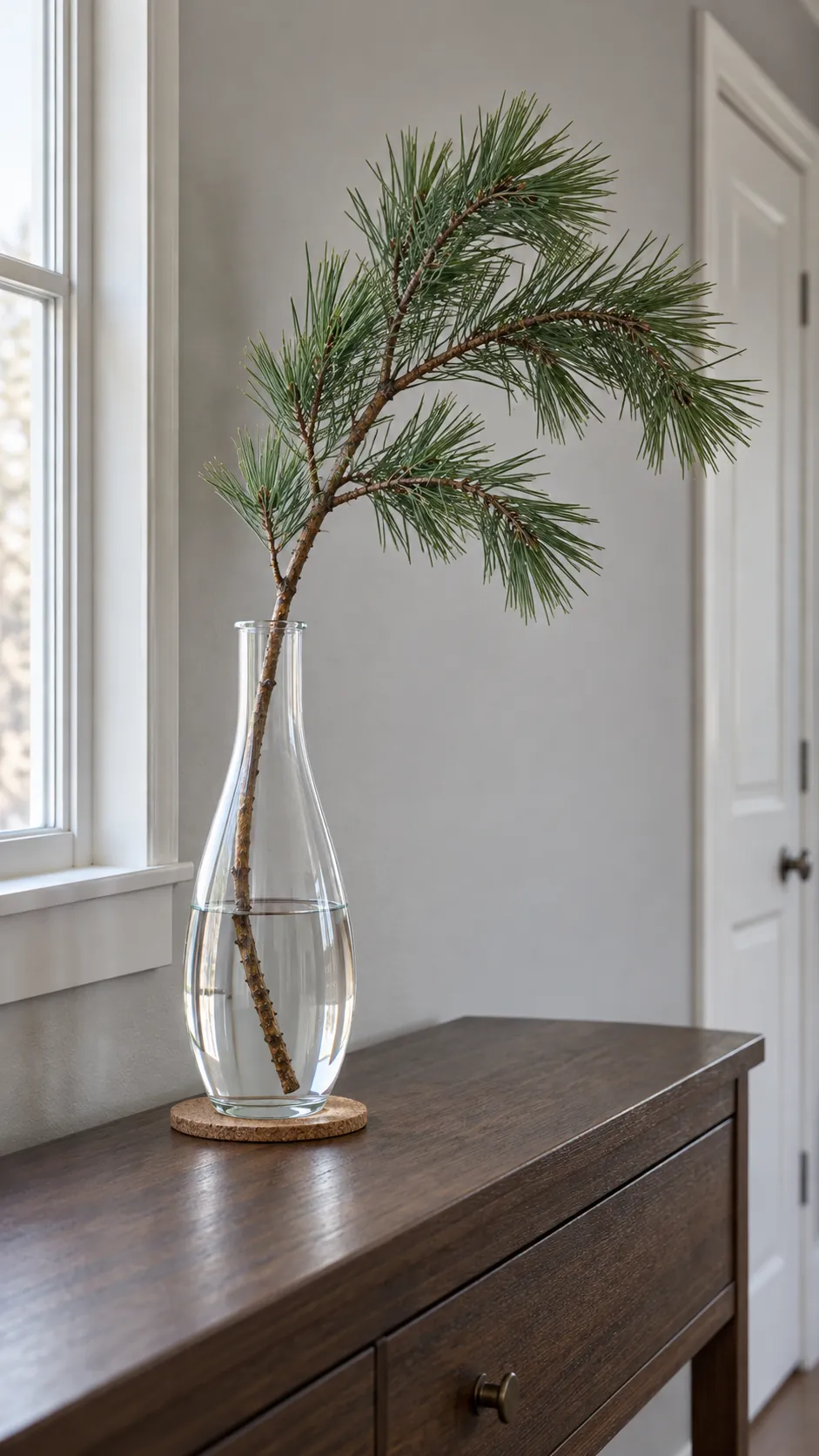 One pine branch in a clear vase for minimalist Christmas decor