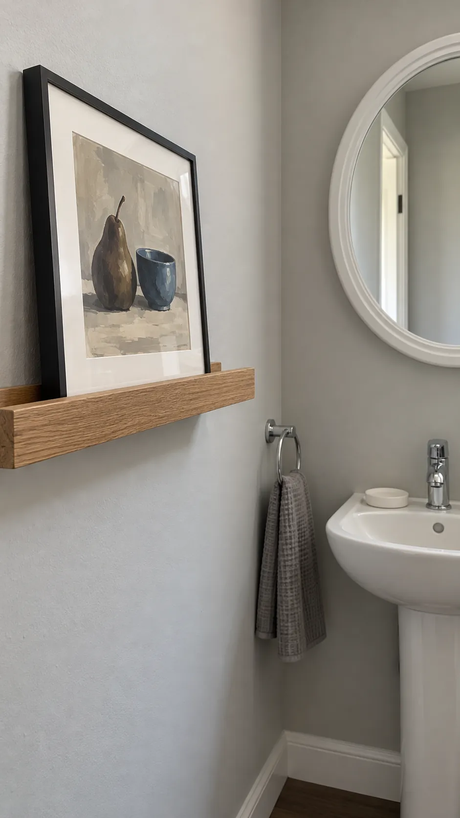 Still life on a shallow ledge paired with a round powder room mirror