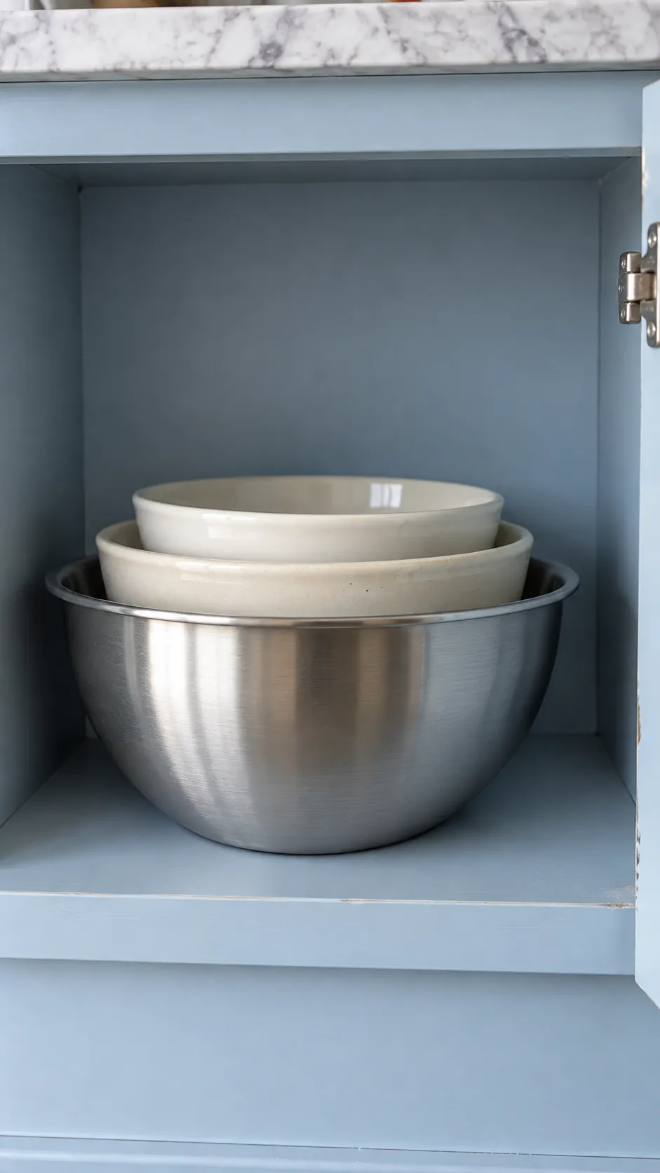 Nested mixing bowls with useful lifting clearance above in a small rental kitchen