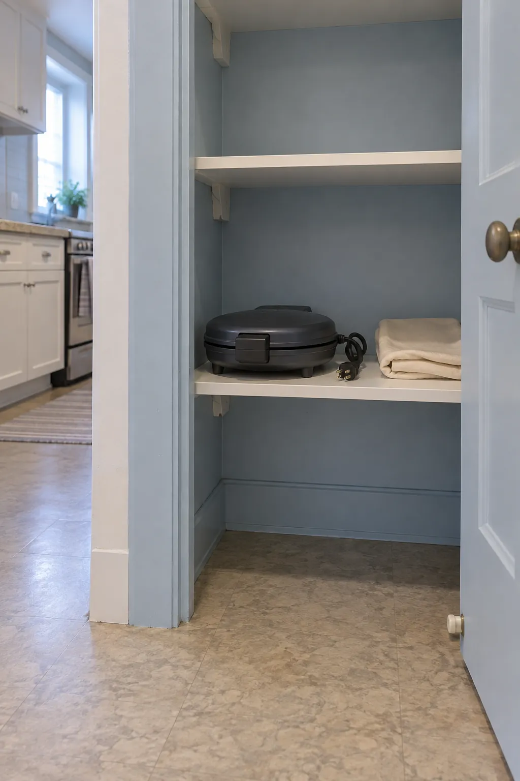 Seasonal waffle maker stored clean and unplugged in a dry hall cupboard