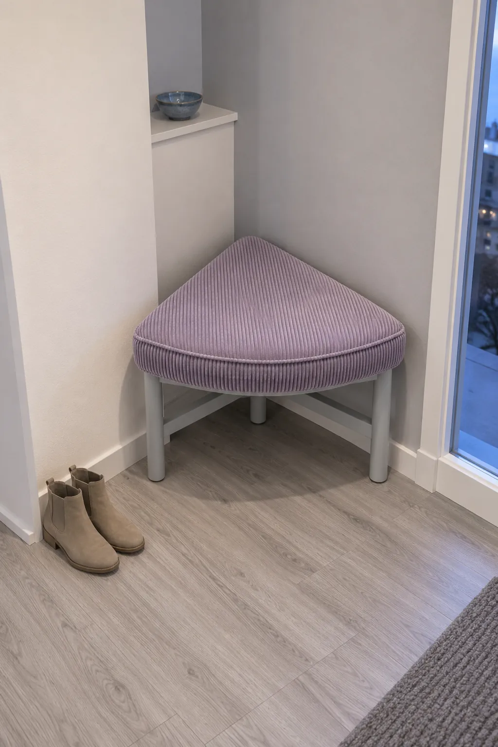 Triangular upholstered stool fitted into a shallow entry alcove
