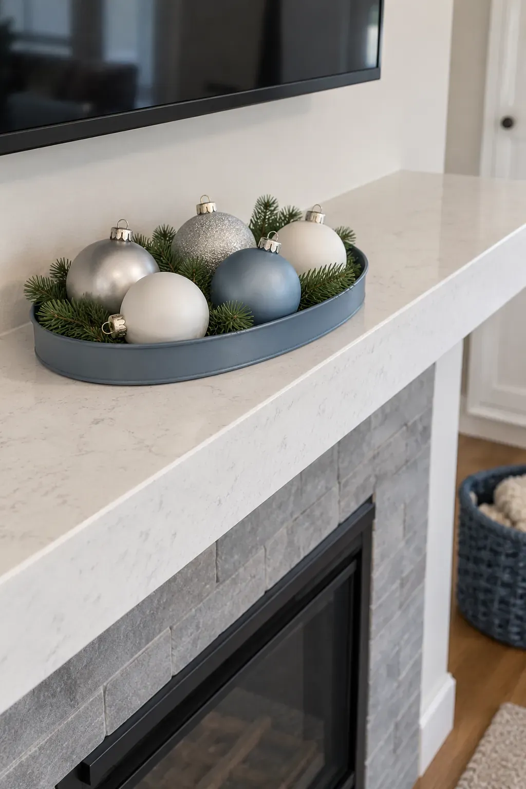 Gather small ornaments in a shallow tray on a Christmas mantel with a television