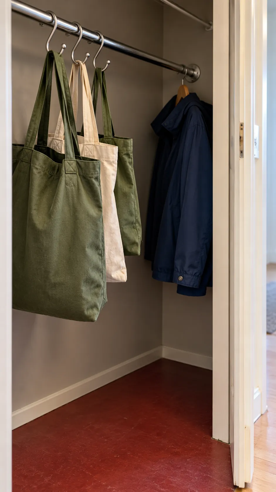 Reusable bags hanging from hooks on an existing entry closet rail
