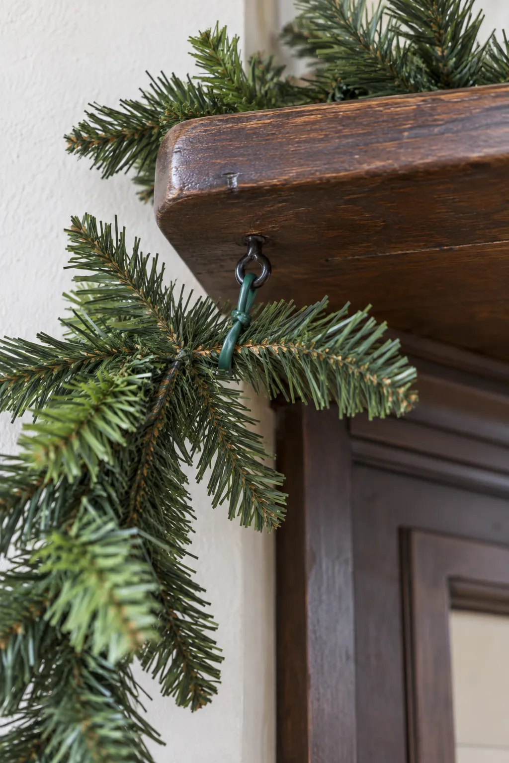 Support the corner before you build fullness when arranging asymmetrical mantel greenery