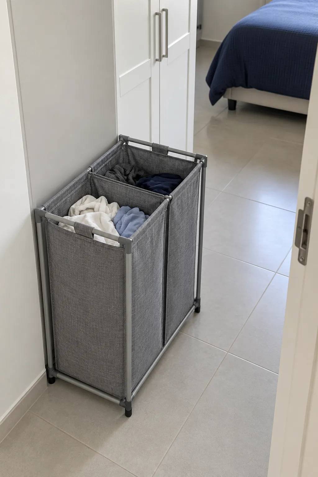 Split laundry with a narrow two compartment hamper in a small shared bedroom