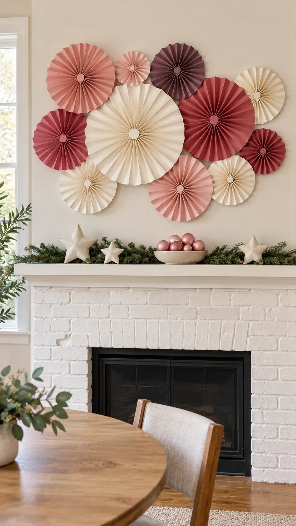 Blush and rose paper fan rosettes above a simple Christmas mantel