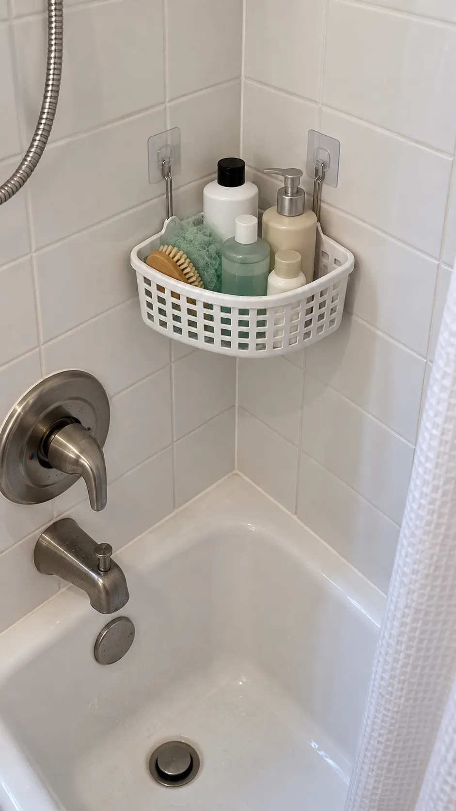 A Corner Basket on Grout Line Hooks used for storage in a small tub shower with no niche